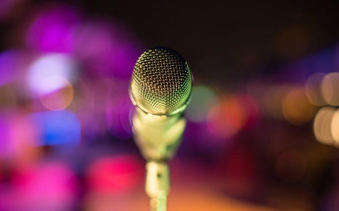 En mikrofon framför en färgglad bakgrund.