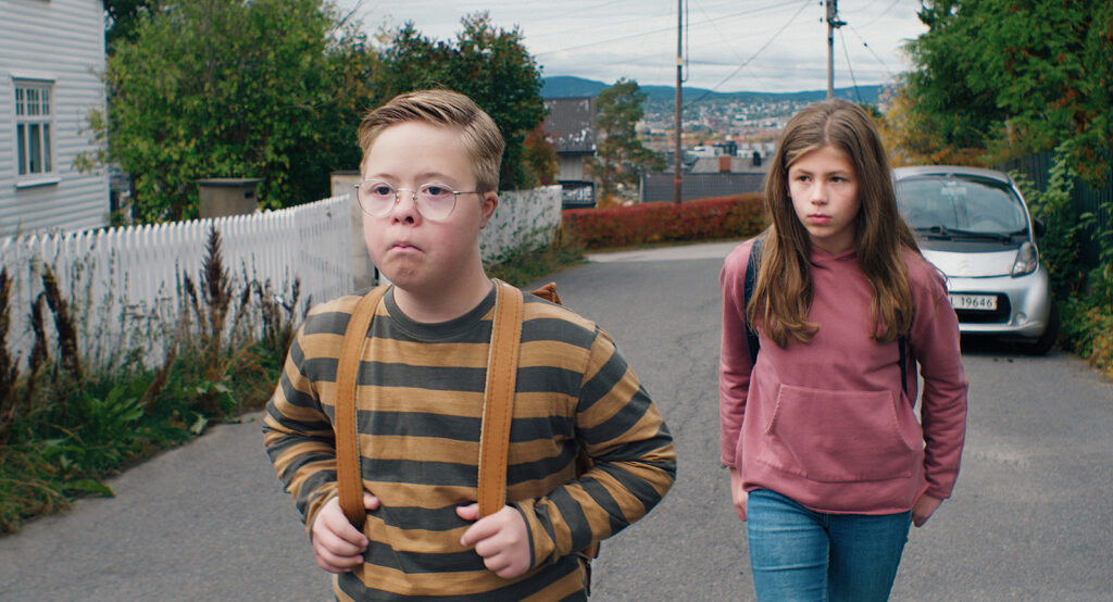 En pojke och en flicka går på en gata.