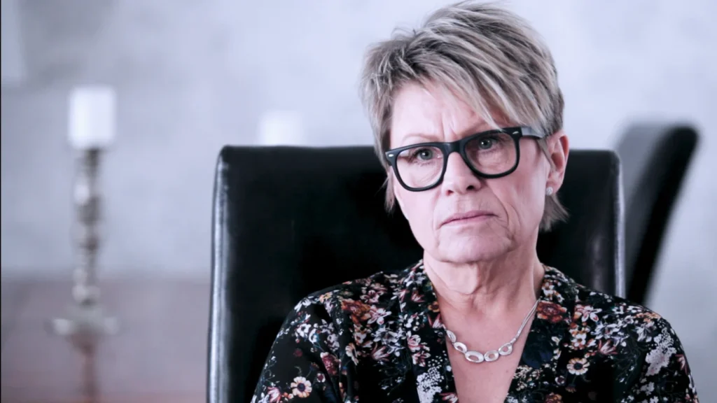 En kvinna sitter i en fåtölj.