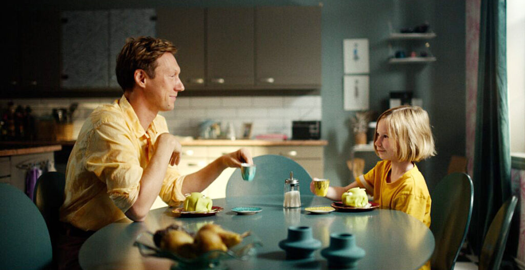 En man och en flicka vid ett köksbord.