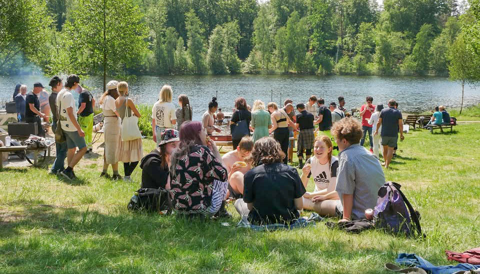 Ungdomar sitter vid en sjö.